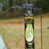 A stick of Ostara Incense burning in a field beside its packaging