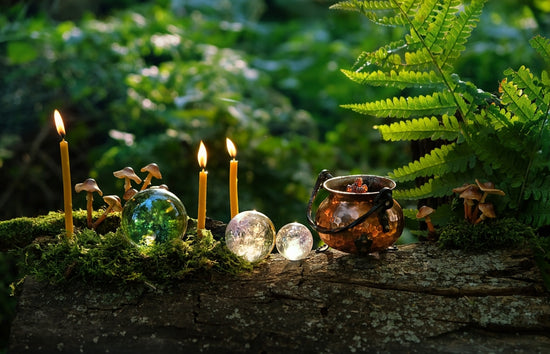 witch cauldron, candles and crystal balls on stump in forest, abstract natural dark background. occult esoteric spiritual practice. wiccan magic ritual, witchcraft. fairytale, mystery atmosphere.