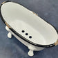 Rustic clawfoot bathtub soap dish from above, showing drainage holes