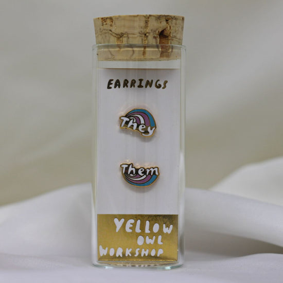 Yellow Owl Workshop Stud Earrings - Each with a nonbinary flag colored rainbow, one says They and the other says Them.