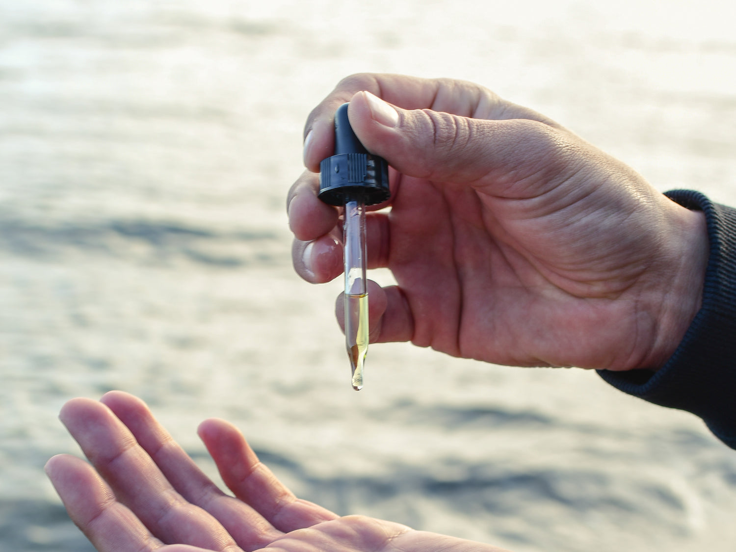 Hands holding an oil dropper