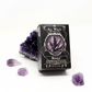 Roque grooming soap in its black box on white background with amethyst crystals around it.