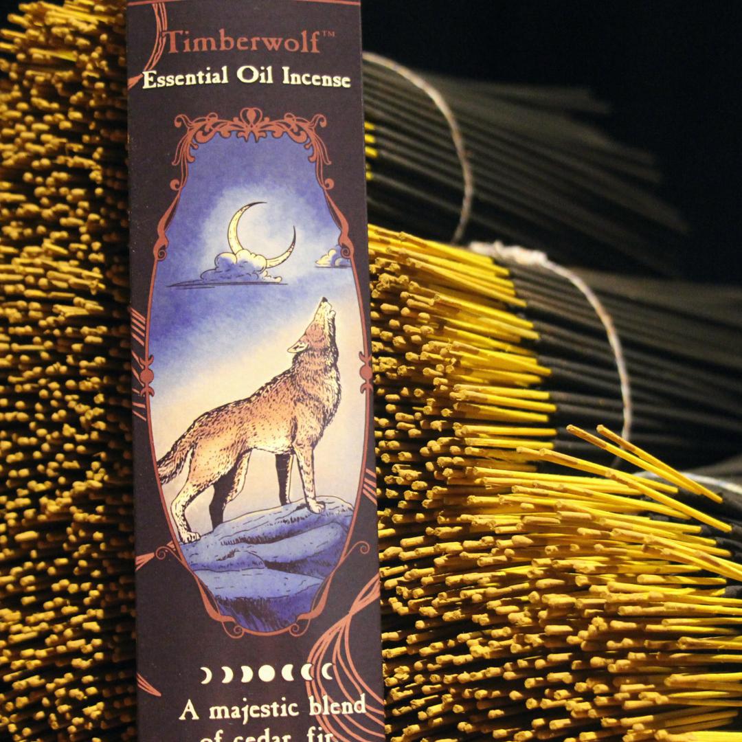 A 20 pack of Timberwolf essential oil incense is posed against a stack of bundled Timberwolf incense sticks.