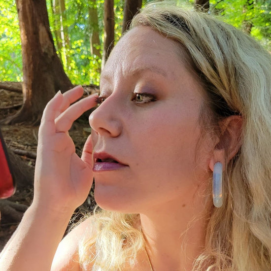 model applying amethyst lip and cheek tint to eyes
