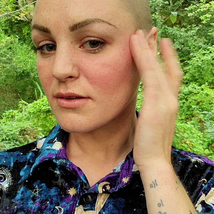 Model wearing coral lip tint on her lips and cheeks