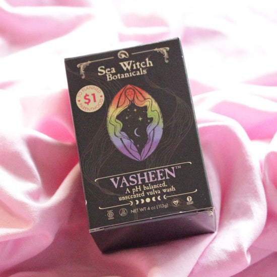A box displaying the Vasheen name and logo lays upon pink fabric.