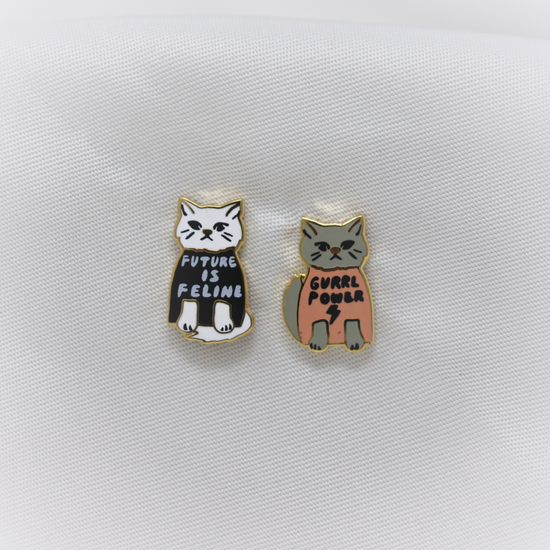 Yellow Owl Workshop Earrings - Gurrl Power. One is a white kitten wearing a black shirt that says "Future is Feline". The other is a gray kitten wearing a pink shirt that says "Gurrl Power".